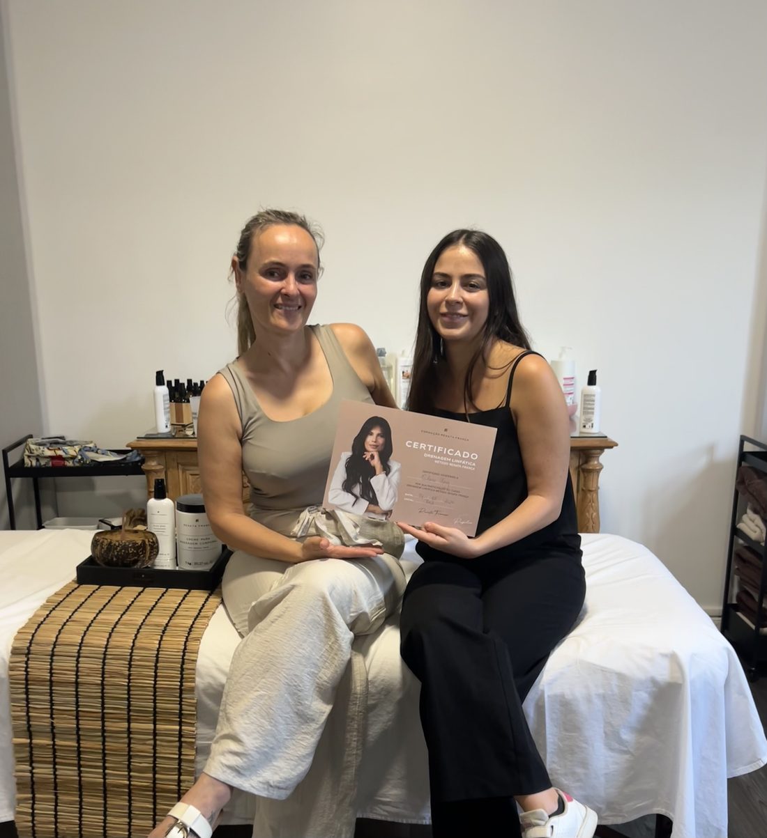 Deux femmes tenant le certificat de formation Drainage Lymphatique Méthode Renata França, dans le cabinet